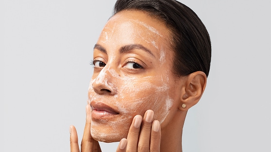 photo of woman using facial cleanser for skintype on face